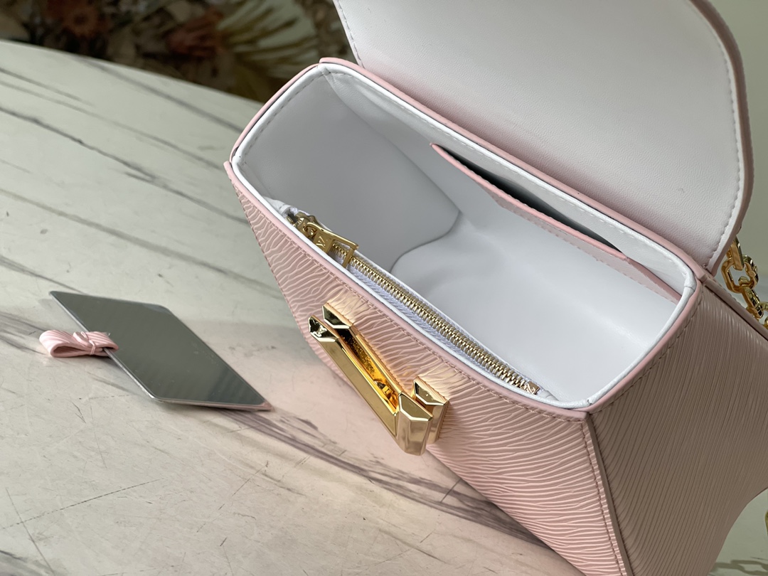 M21027 Pink Shuttle Lock 50332 Pink Shuttle Lock This Twist small handbag is made of Epi leath