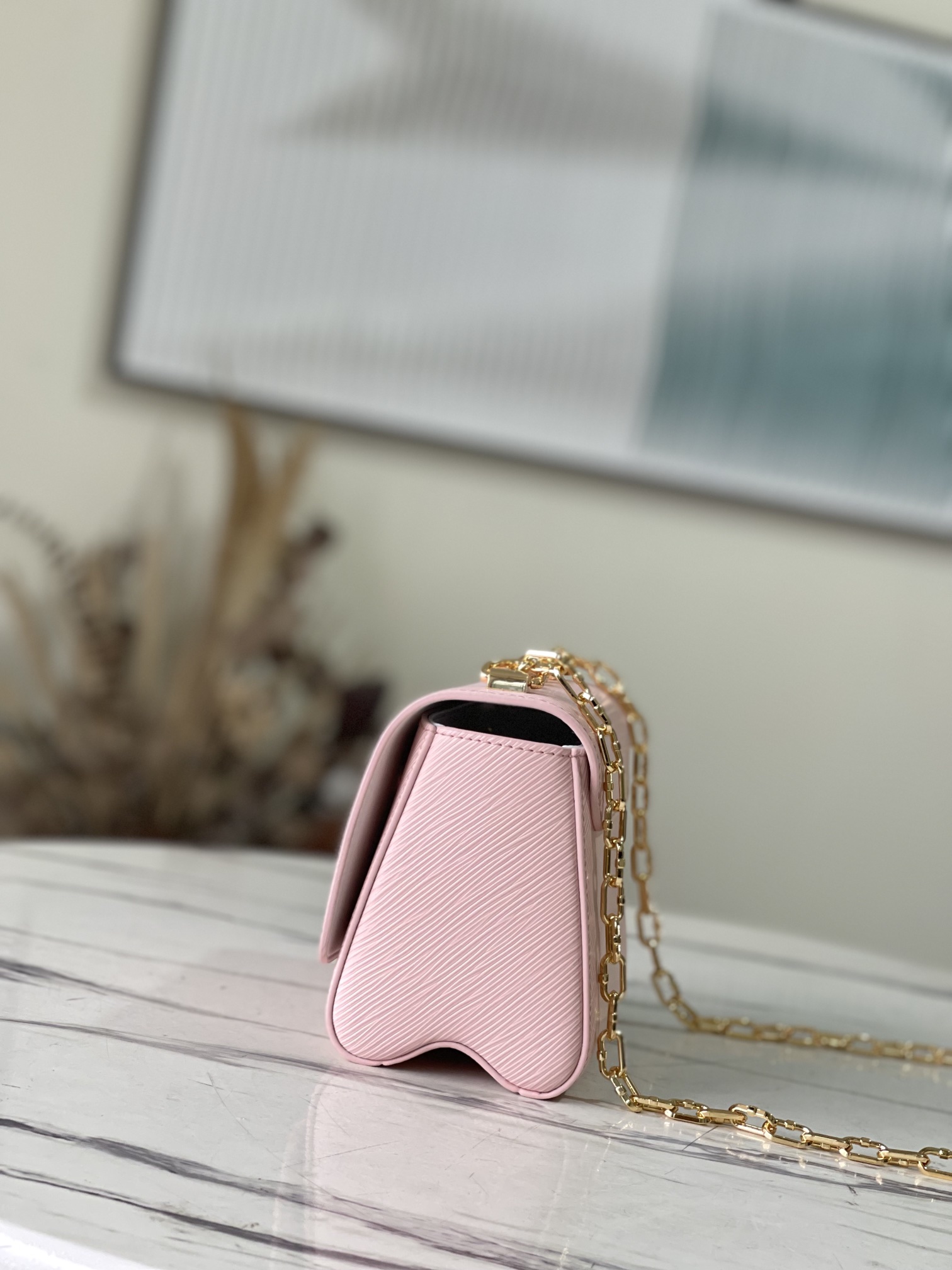 M21027 Pink Shuttle Lock 50332 Pink Shuttle Lock This Twist small handbag is made of Epi leath