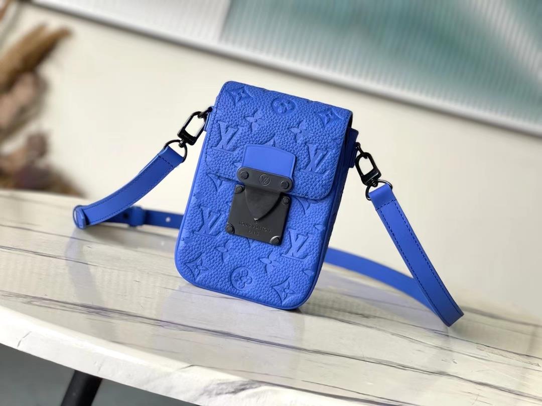 The M82568 blue SLock Vertical mini handbag features an iconic SLock buckle inspired by George Vuit